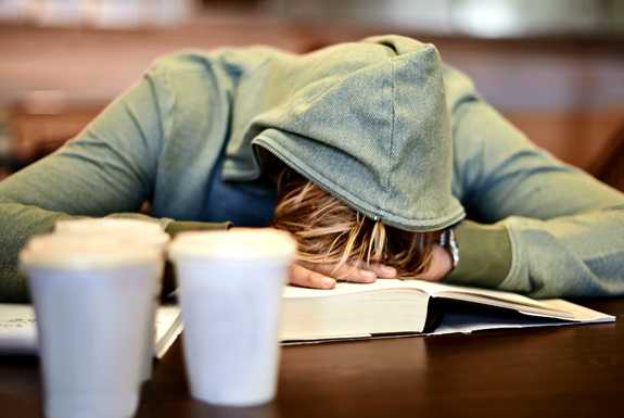a teenager asleep at his school desk