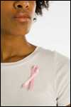 A woman wears a pink breast cancer ribbon.