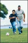 Photo: A boy plays soccer with an adult male