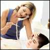 A mother takes her son's temperature while on the phone with the doctor