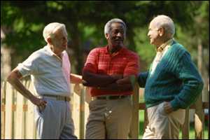 Three older men talking outside