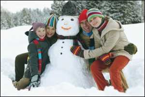 A family poses with a snowman