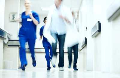 Healthcare professionals running down a hallway.