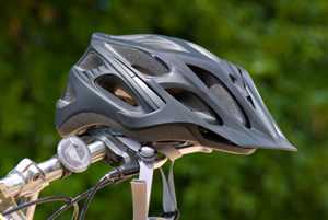 photo: helmet hanging from bicycle handlebars