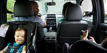 Photo: children in car seats in backseat with parents in the front