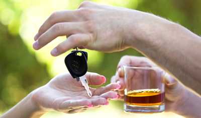 photo: man holding a drink handing over his car keys