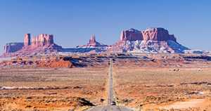 photo: car on a highway approaching Monument Valley