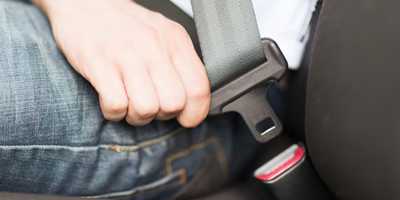 photo: man buckling seat belt