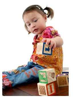 A young girl playing with blocks.