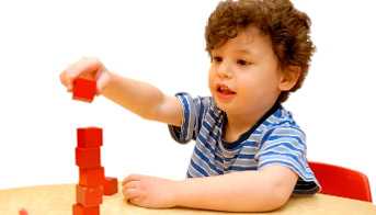 Boy stacking blocks on a desk
