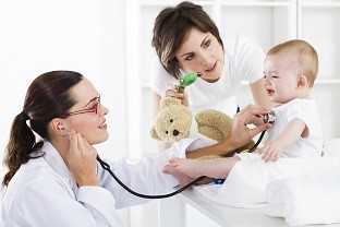 Pediatrician with mother examining baby