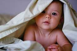 Baby crawling in blankets.
