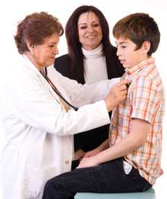 Doctor examining boy with mother watching