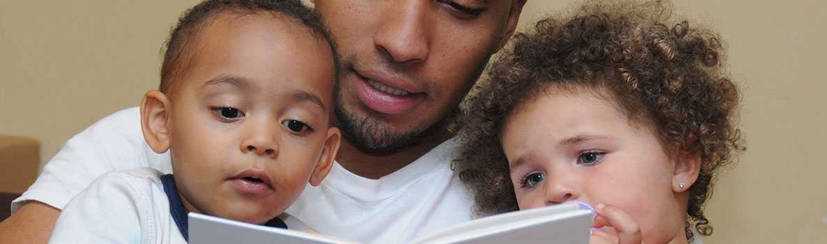 A father reading to his children. 