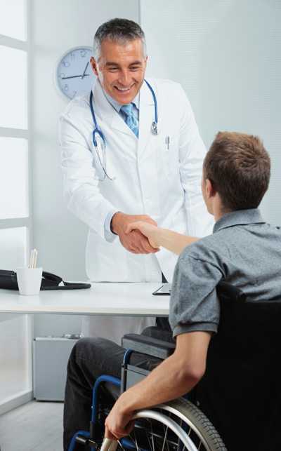 Doctor shaking hand of a man in a wheelchair