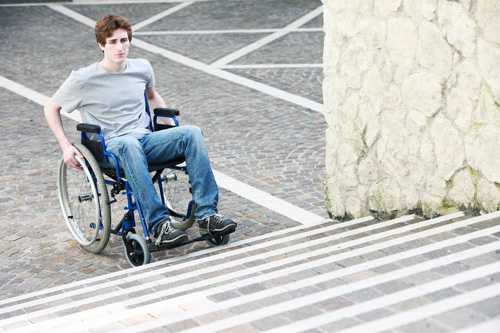 Man at the bottom of steps in a wheelchair