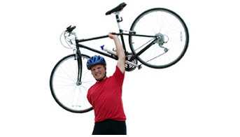 A man holding a bike above his head.