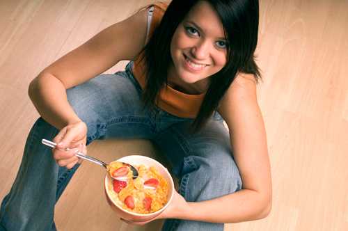 Imagen de una mujer joven comiendo cereal
