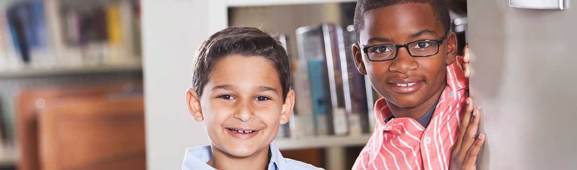 Dos niños sonriendo en la biblioteca