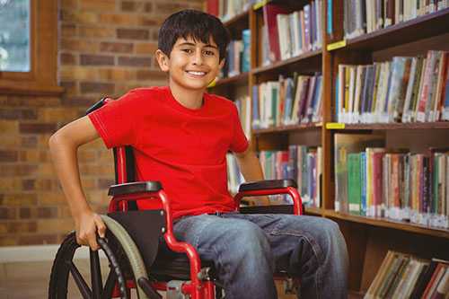	Un niño en una silla de ruedas en la biblioteca