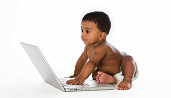 A baby playing on a laptop computer
