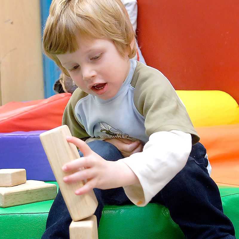 A boy builds a tower out of blocks.