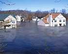 Photo of a flooded neighborhood with water levels covering the bottom of the houses.