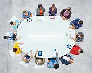 Group of people meeting at a circular table.
