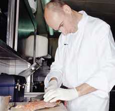 Photo of chef preparing fish filet.
