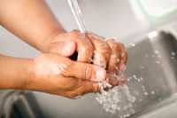 Close up photo of a man washing his hands.