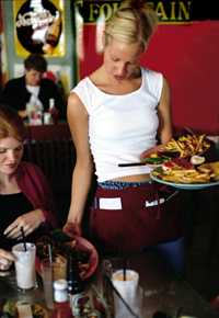 Photo of a waitress serving multiple plates in a restaurant." 