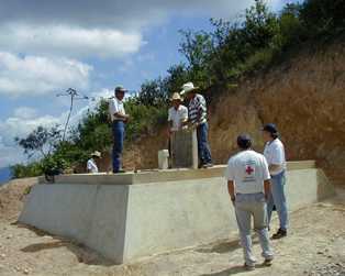 Men assessing storage tank for rural water system in Guatemala