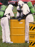 hazardous material workers inspecting a barrel