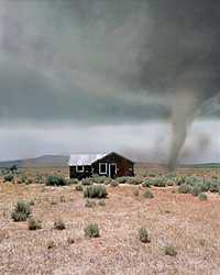 Photo of tornado moving across plains approaching house.