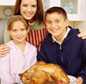 Mother and children holding cooked turkey
