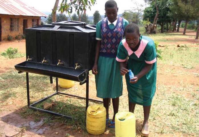 Image of Two members of the safe water club at Sino SDA Primary School in Nyanza Province in rural Kenya treating the school drinking water with Water¬Guard.