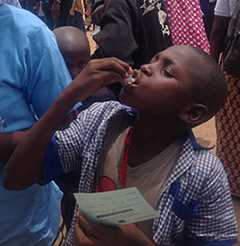 A young boy takes a dose of the oral cholera vaccine distributed in his village in northern Cameroon.