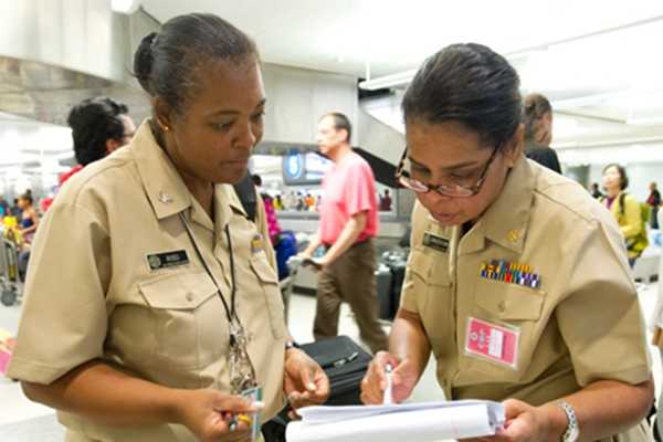 Keysha Ross and Kimberly Crocker, public health officers at the Los Angeles Quarantine Station, review flight information.