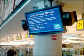 An electronic monitor at O'Hare International Airport displaying measles health advisory.