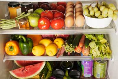 fridge brimming with eggs, jellies, fruits, and vegetables