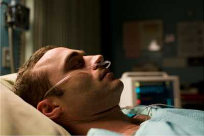 Image of a patient lying in bed asleep with a monitor in the background