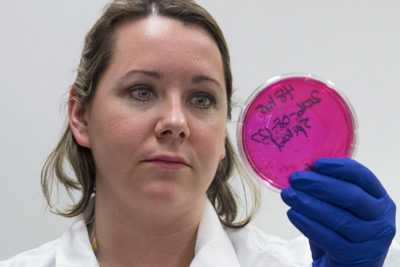 Image of scientist holding a red petri dish
