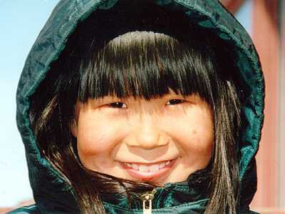 Young Alaskan girl in warm green hooded parka