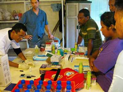 CDC responded to an outbreak of dengue in the Marshall Islands. This image shows a group of people standing around a table full of equipment, watching a demonstration for a rapid diagnostic test that detects the presence of dengue virus in people with dengue-like symptoms.