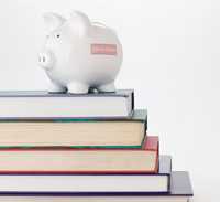 Stack of books with a piggy bank on top