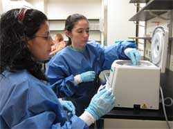 image of two women putting specimen into centrifuging machine