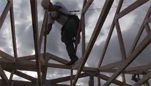 man climbing on a roof frame