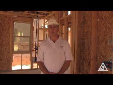 Construction worker inside a wood building frame