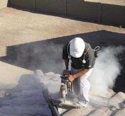 Worker creating a large cloud of dust while cutting