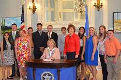 	Oklahoma Governor Mary Fallin (seated, center) signs State Senate Bill 262, with the bill’s sponsor, Oklahoma State Senator Susan Paddack (fifth from right); Mark Costello, Oklahoma Labor Commissioner (center); Lester Claravall, Oklahoma Dept. of Labor (fifth left); Andrea Okun, NIOSH (center); and Stacy Oakley (third from left), her husband, and her students from Latta Schools in Ada, OK, who worked tirelessly to champion the passage of this first-of-its-kind bill.  
